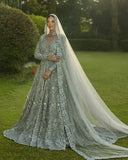 Woman wearing an Ice Blue Net bridal dress with floral embroidery, a bridal dress brand in Pakistan