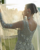 Woman in an Ice Blue Net bridal dress, open-back pearl embroidery, from Mushq's wedding dress collection