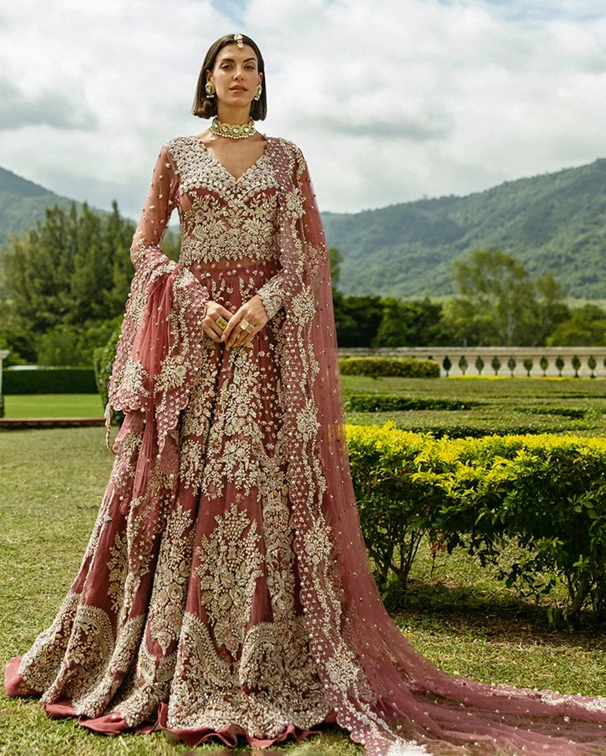 Woman wearing a Tea Pink Net bridal dress with gold embroidery, one of Mushq's bridal dresses