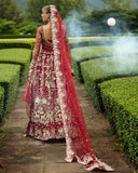 Back view of woman wearing blood red embellished Net bridal lehenga with sheer veil