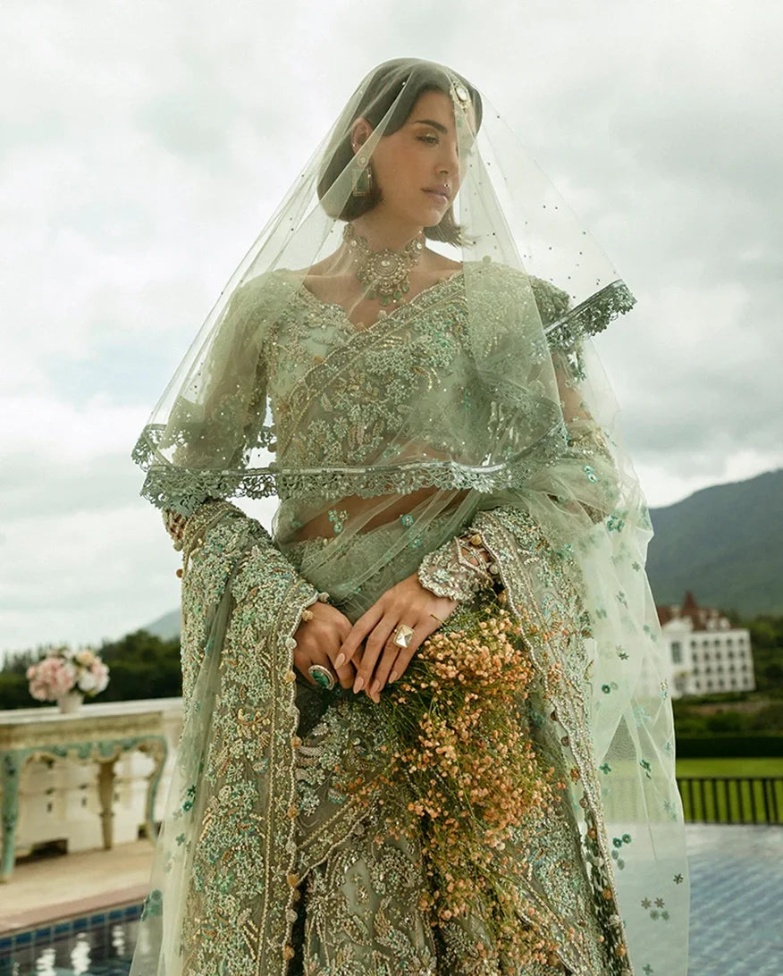 Close-up of woman wearing aqua green embellished Net bridal lehenga with sheer veil and jewelry