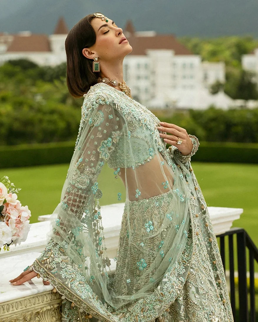 Side profile of woman wearing aqua green embellished Net bridal dupatta with sheer sleeves
