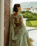 Back view close-up of aqua green embellished Net bridal lehenga with open back detailing