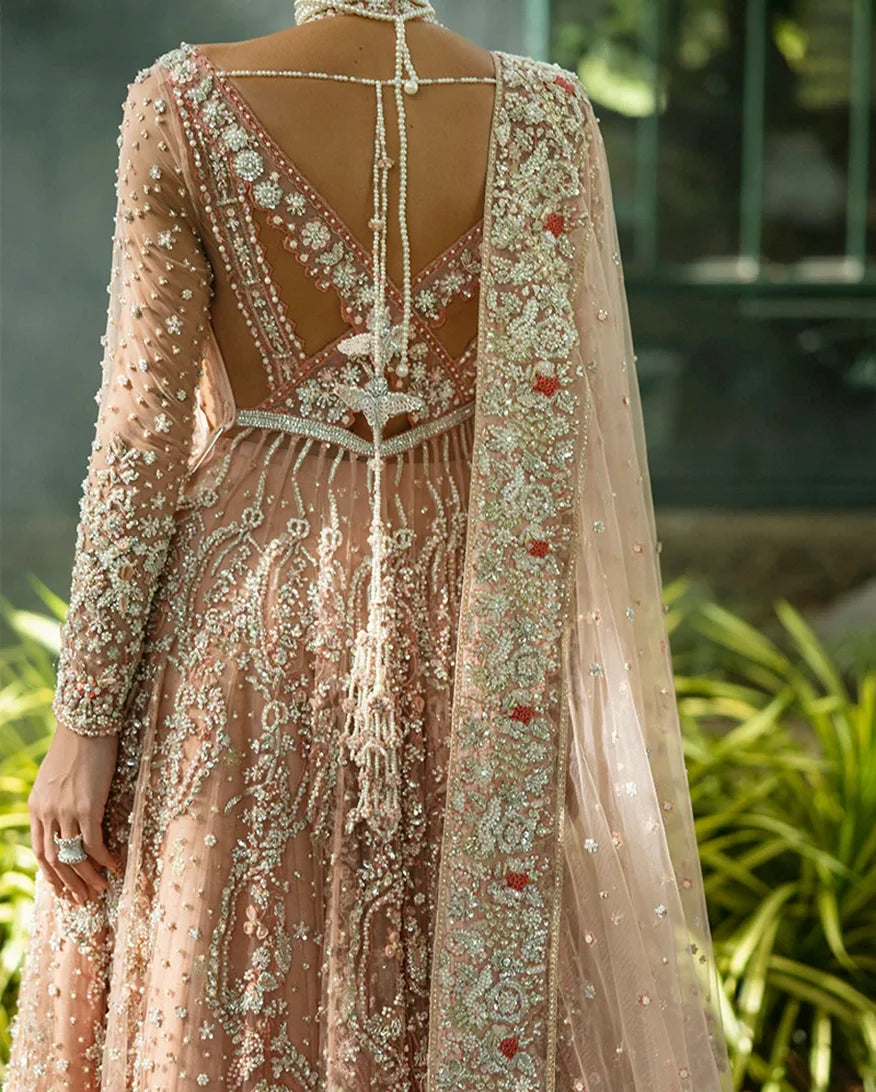 Close-up back view of peach embellished Net bridal lehenga with tasseled back detailing