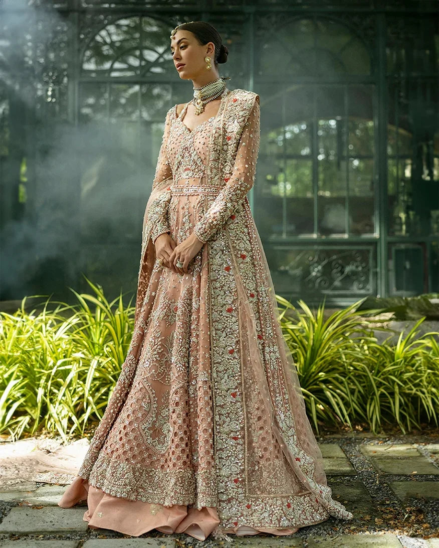 Woman wearing peach embellished Net bridal lehenga with jacket-style bodice