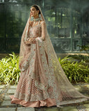 Woman wearing peach embellished Net bridal lehenga with sheer dupatta, front view