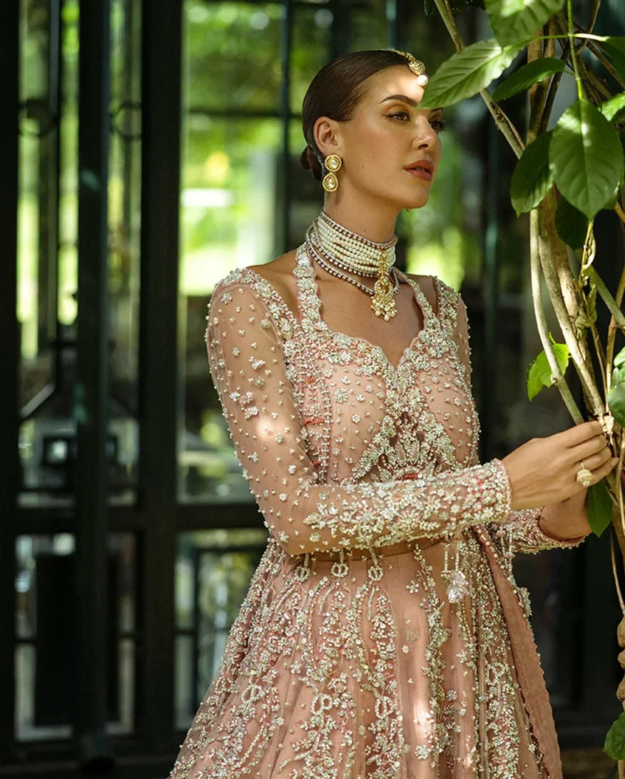 Close-up of woman wearing peach embellished Net bridal bodice with pearl embroidery