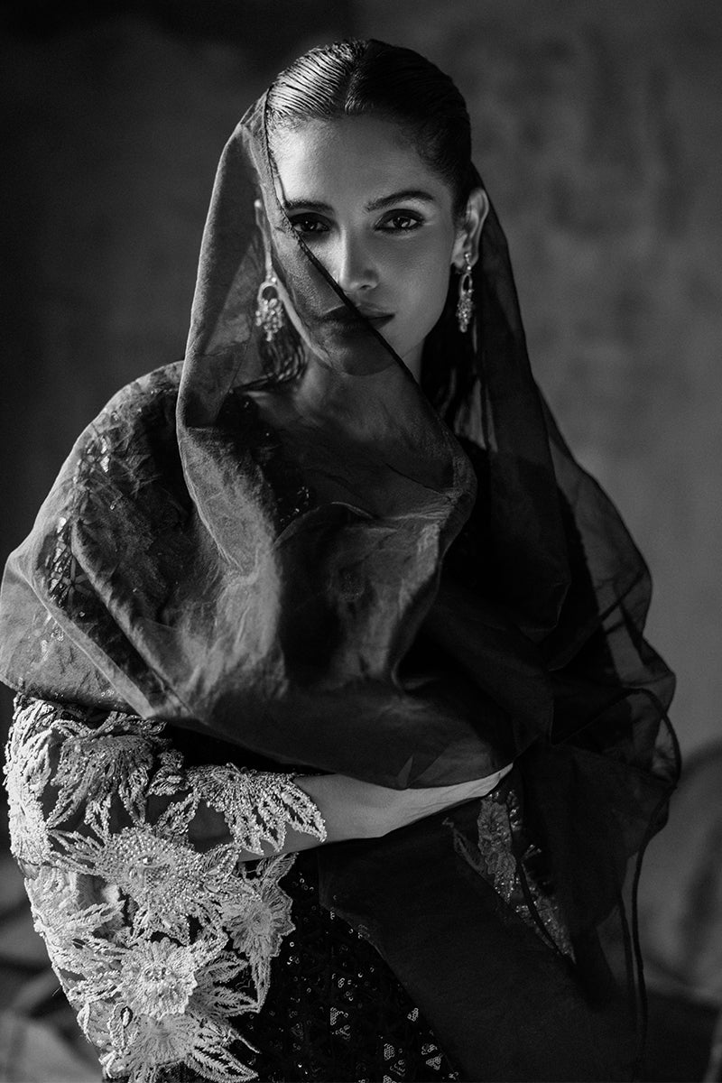 Black-and-white close-up portrait with a sheer organza veil framing the face