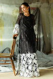Woman wearing a Black Net suit, looking down at an embroidered floral hem