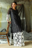 Woman wearing a Black embroidered Net suit, glancing to the side beside a wooden chair