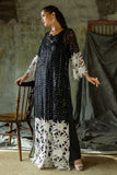 Side profile of a Black embroidered Net suit, hand resting on a wooden chair