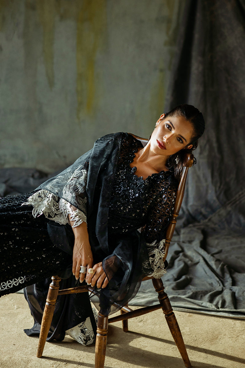 Styled seated portrait in a Black Net suit, draped across a wooden chair