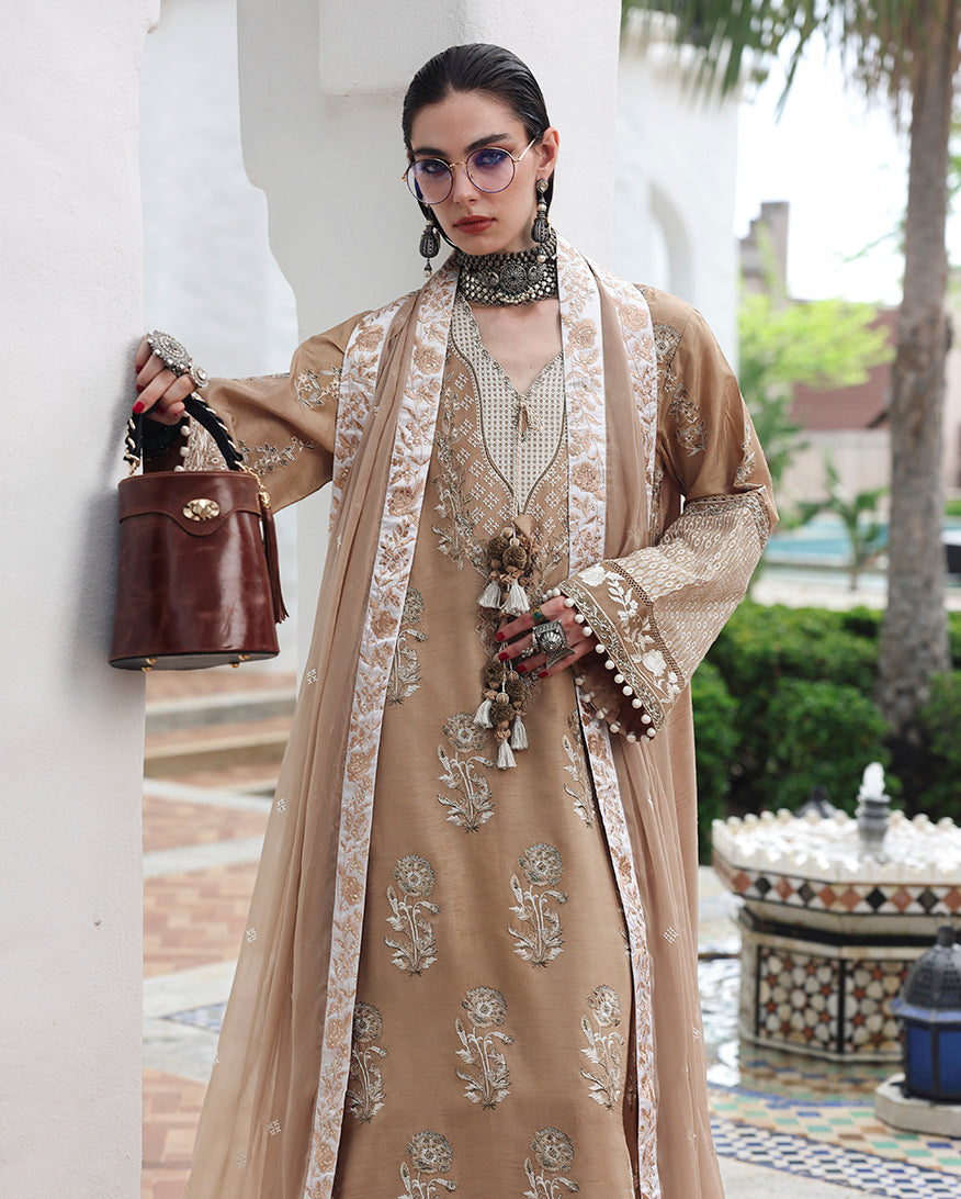Woman wearing beige raw silk dress with hand embellished silk sleeve balls at the cuff