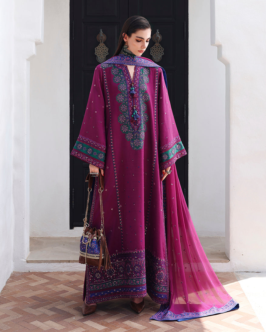 Woman wearing magenta embroidered raw silk suit with sequinned border and embroidered chiffon dupatta