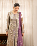 Woman wearing golden beige lama silk suit, close-up looking down, smiling