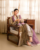 Woman wearing golden beige lama silk suit, seated, side view, adjusting bracelet