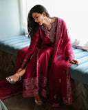Seated styled shot of magenta pink luxury pret suit with embroidered hem, Zarminay collection