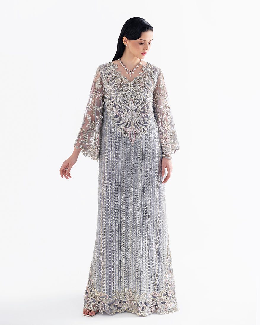 Woman wearing grey embroidered net suit with beaded bell sleeves and scalloped hem