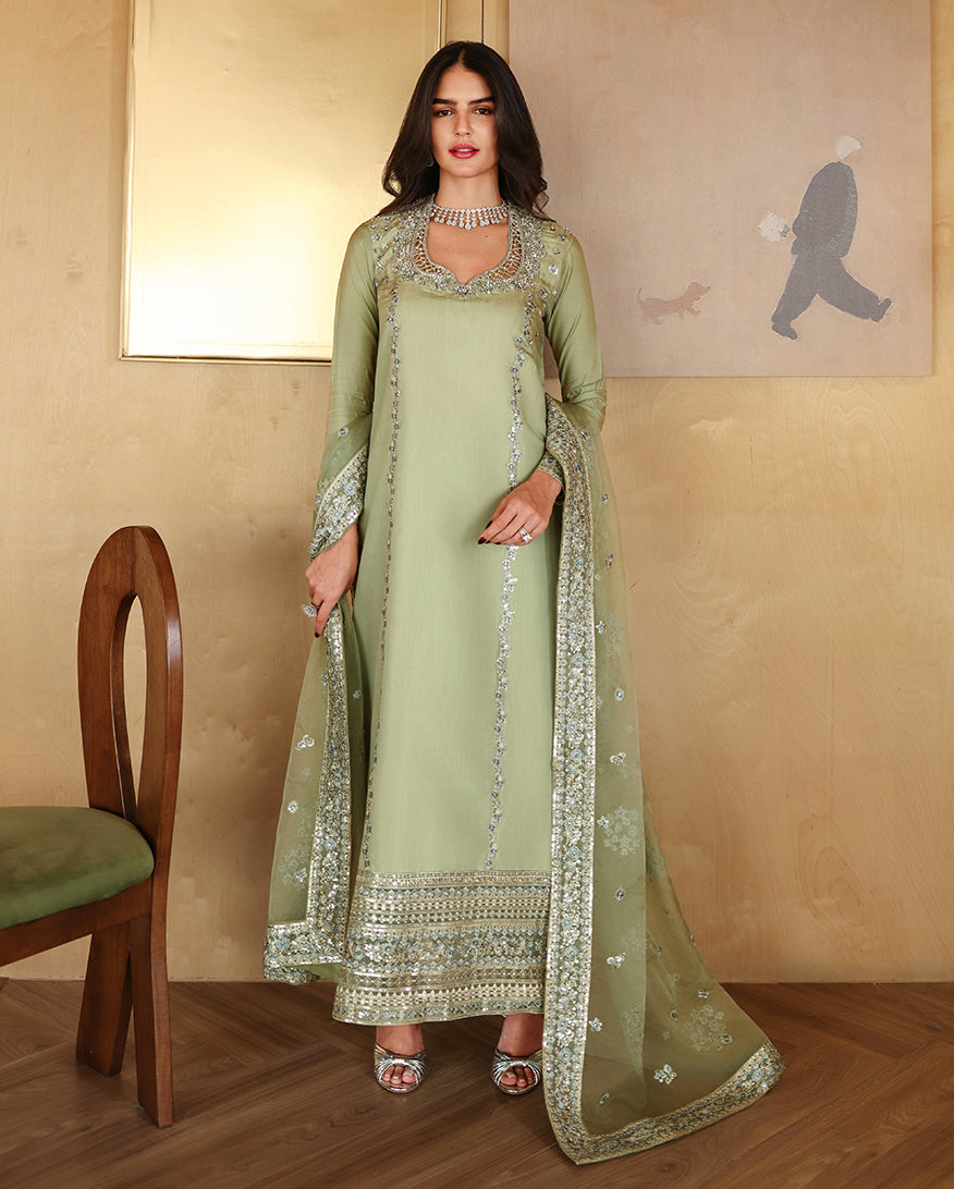 Woman wearing a sage green luxury pret suit with silver mirror-work embroidery, Zarminay collection