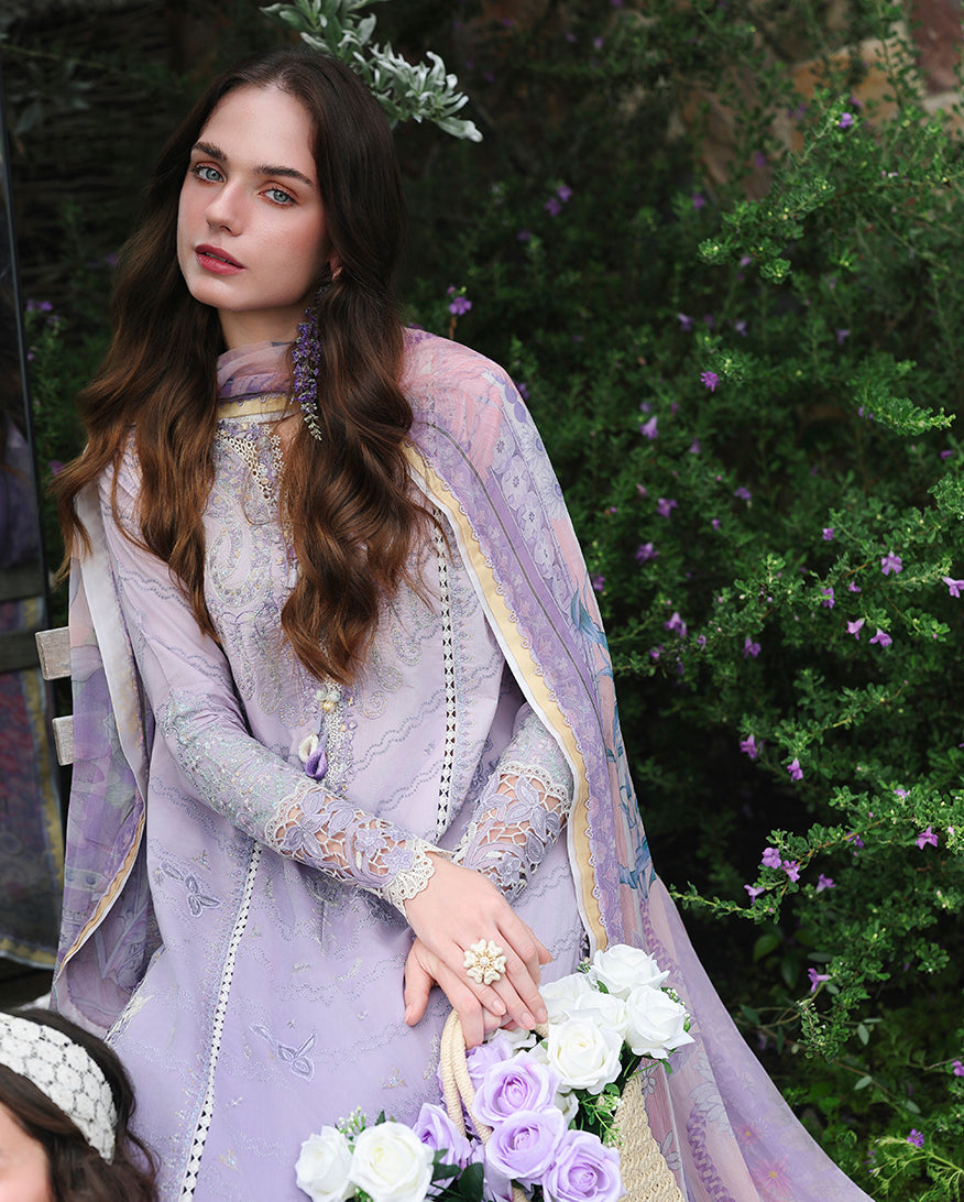 Woman wearing lavender embroidered lawn collection suit with sheer patterned cape, holding rose bouquet, Secret Garden collection