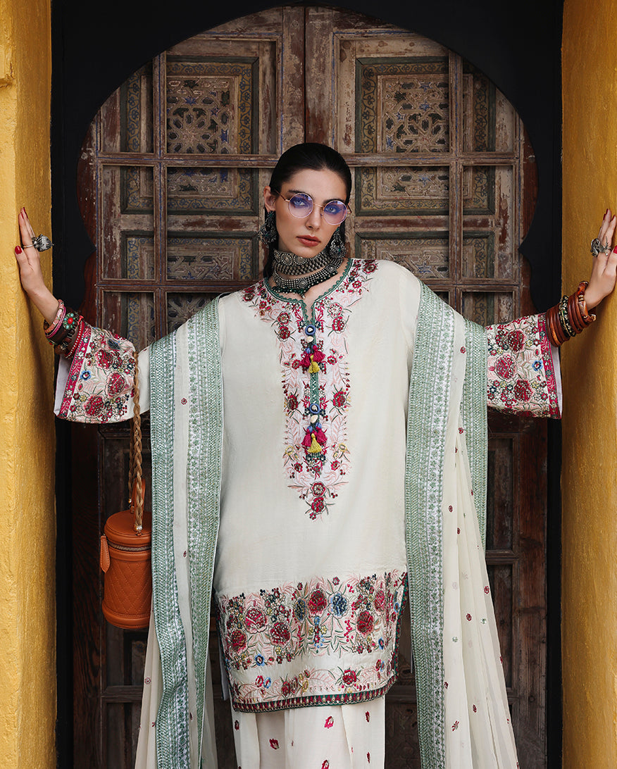 Woman wearing white raw silk dress with dupatta draped over both arms