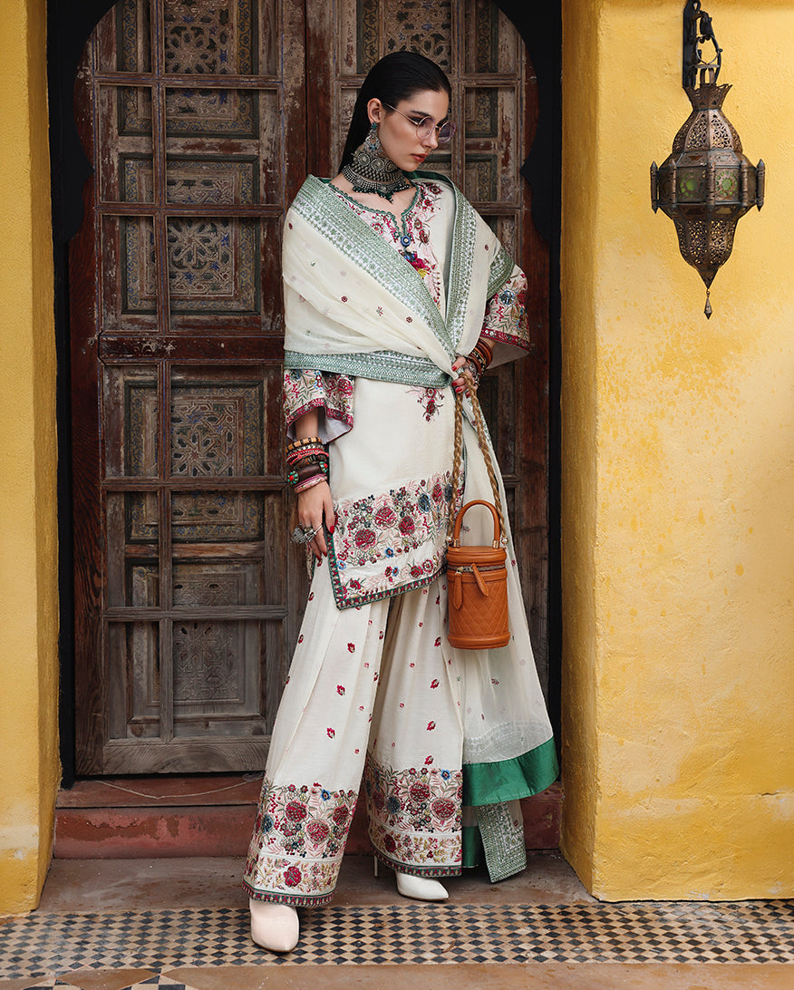 Side view of white raw silk dress showing embroidered silk trouser border and sleeve embroidery