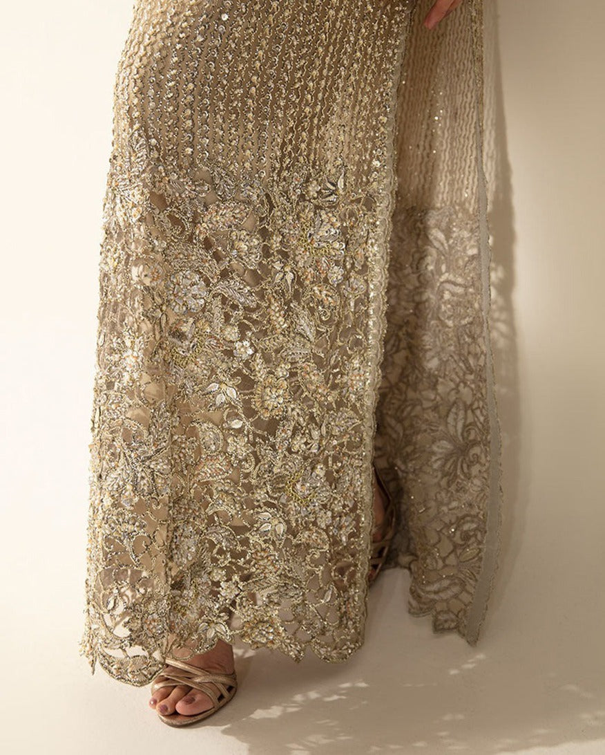 Close-up of crystal and pearl embellished hem detail on a Pale Gold Net suit