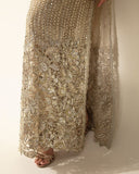 Close-up of crystal and pearl embellished hem detail on a Pale Gold Net suit