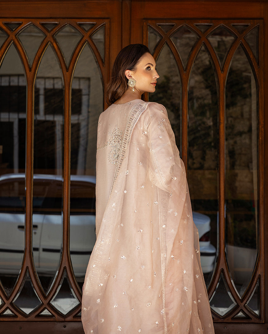 Back view of rose beige raw silk suit showing embroidered dupatta and looking over shoulder