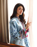 Close-up of embroidered sleeve and neckline on blue printed raw silk suit by a window