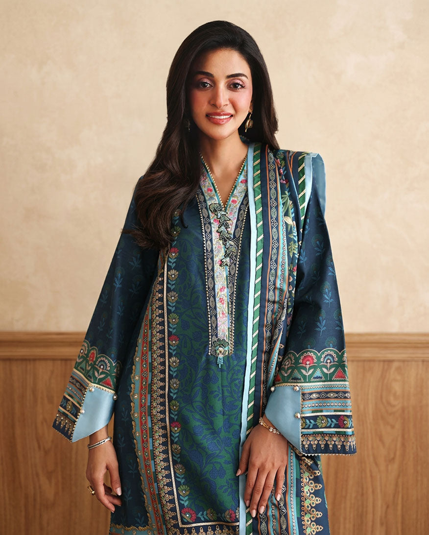 Close-up of embroidered neckline and hand embellished buttons on blue raw silk shirt