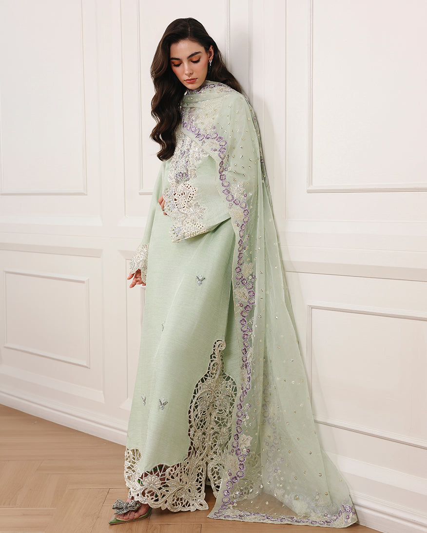 Side view of pista green Korean raw silk long shirt with embroidered hem and organza dupatta over shoulder