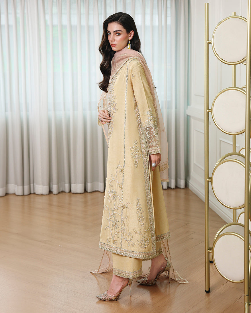 Side view of lemon yellow Korean raw silk suit with embroidered hem, straight trouser and organza dupatta