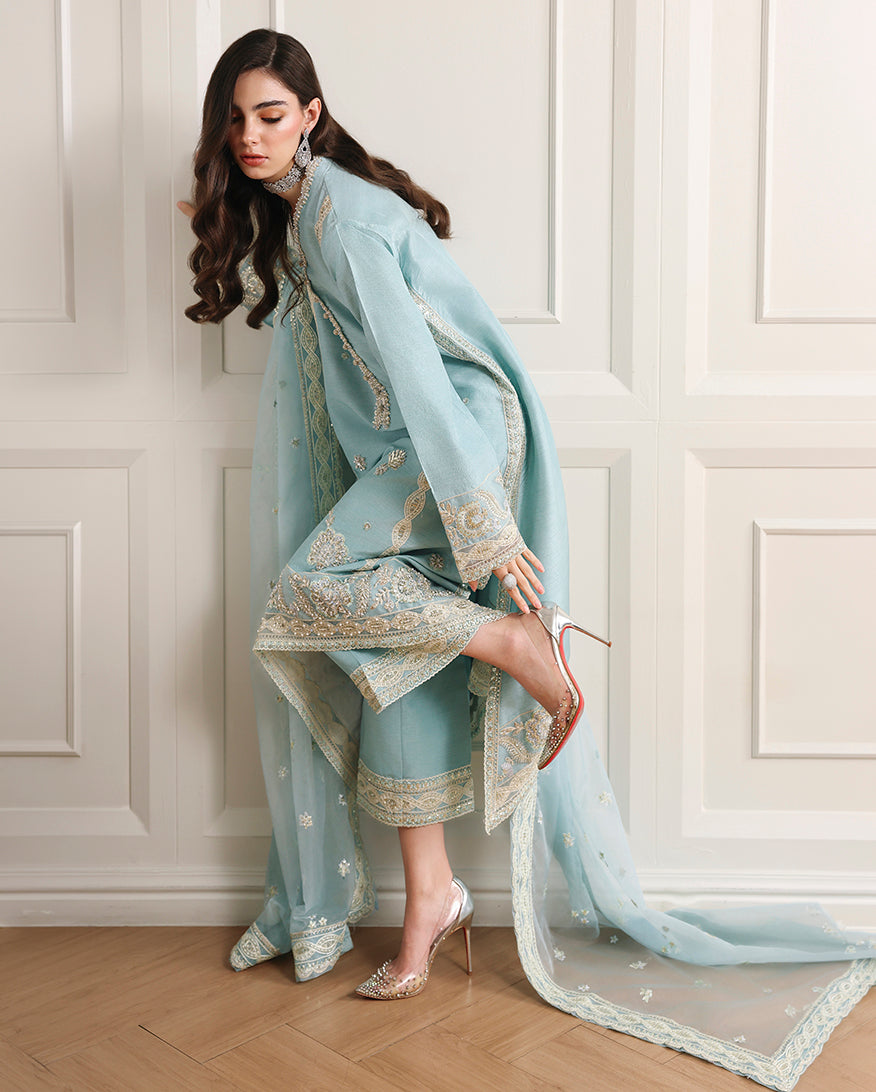 Side view of sky blue Korean raw silk shirt with embroidered hem, matching trouser and organza dupatta