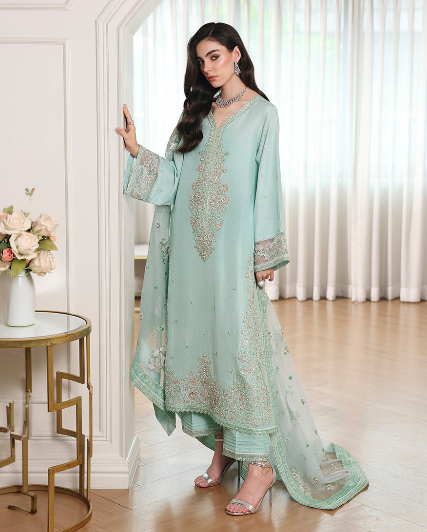 Side view of blue Korean raw silk mid-length shirt with embroidered hem and organza dupatta trailing behind