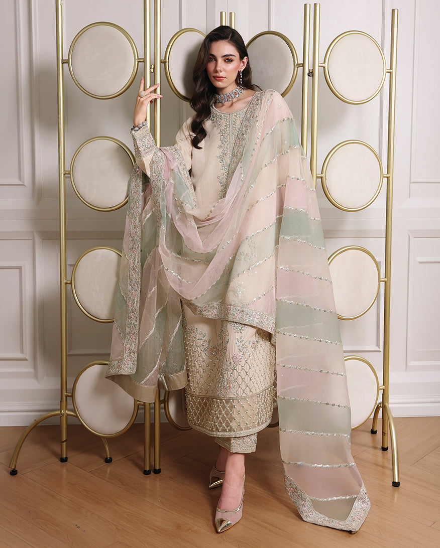 Woman wearing off white Korean raw silk three-piece suit with translucent organza dupatta draped across the front