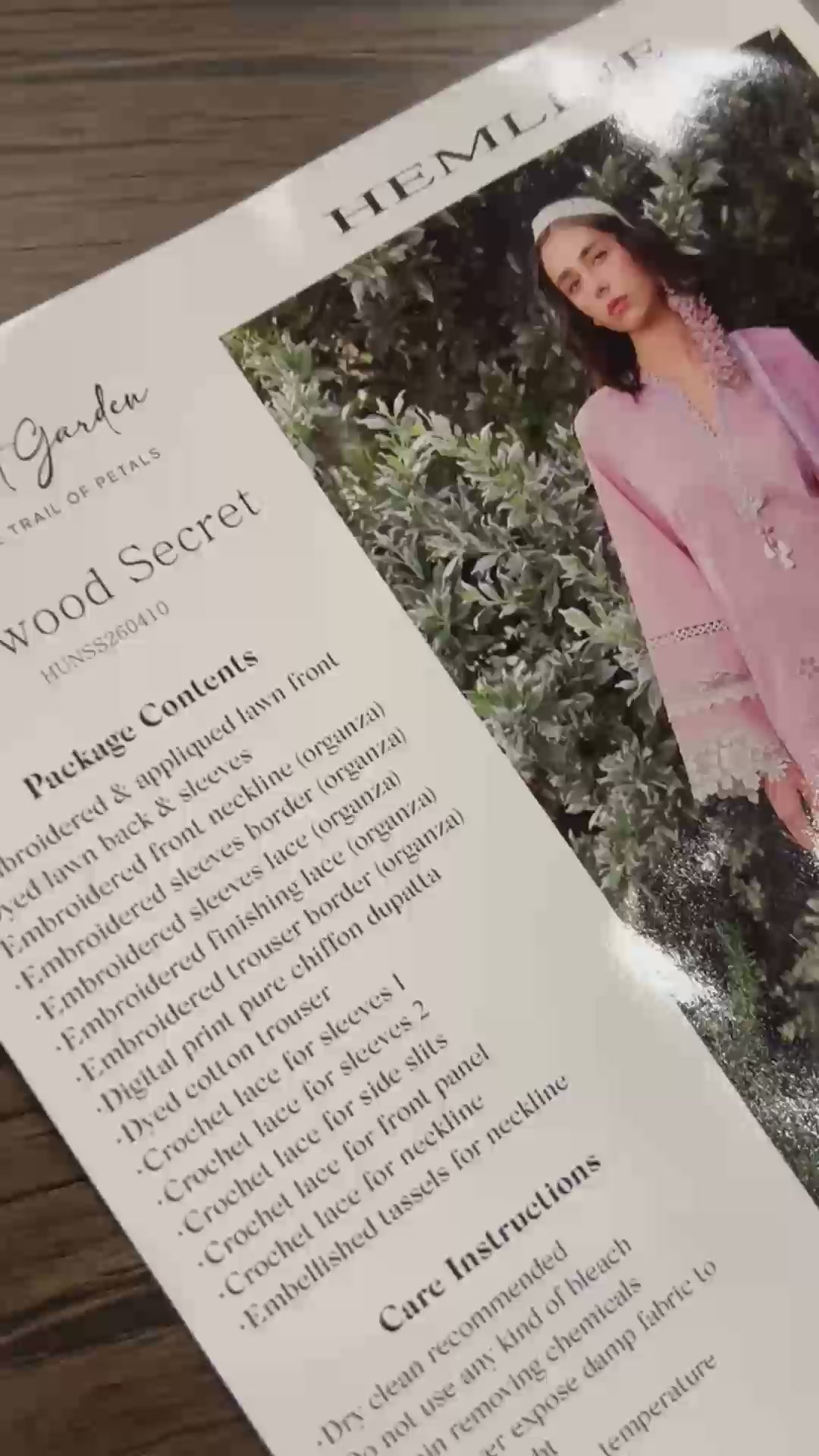 Woman wearing a light pink lawn suit with floral garland headpiece in garden, Secret Garden collection
